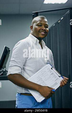 Computer consultant at your call. Portrait of a confident IT technician working in a data center. Stock Photo