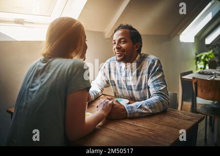 To think of you is to smile. a young couple spending time together at a cafe. Stock Photo