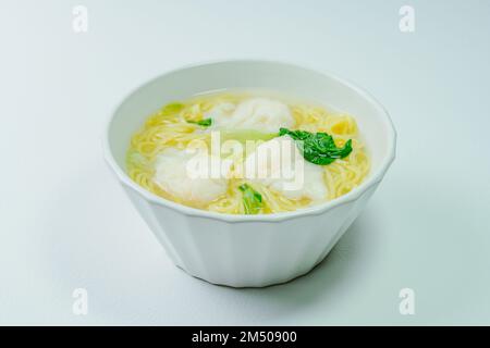 Chinese cuisine shrimp wonton dumpling noodle soup food in white bowl on white table background Stock Photo