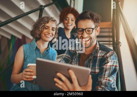 Discovering new ways to innovate together. creative employees having a discussion on the staircase at work. Stock Photo