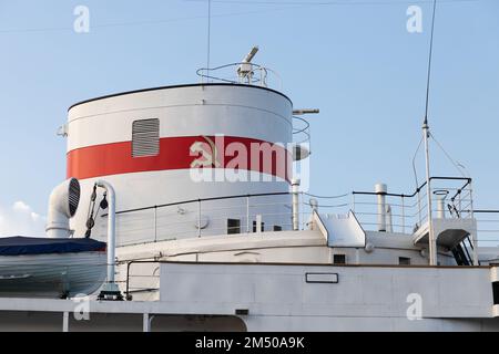 Chimney of a vintage white ship with red stripe and the hammer and sickle design from the flag of the Soviet Union Stock Photo