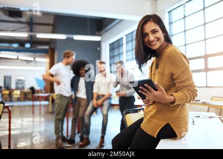 Ive got something big on the way. Cropped portrait of an attractive young businesswoman in the office with his colleagues in the background. Stock Photo