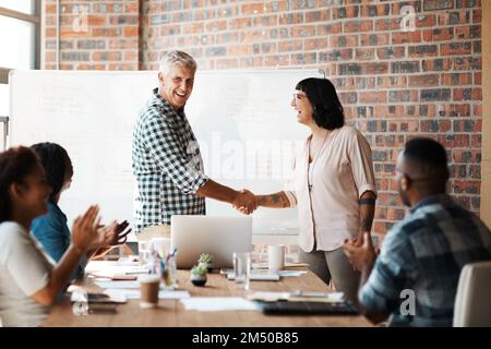 Outsourcing one the best. a businessman and businesswoman shaking hands during a meeting in the boardroom. Stock Photo