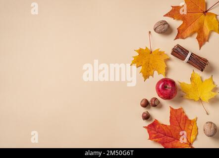 Autumn flat lay with bright colorful maple leaves  with apple and nuts on orange background. Top view and copy  space. Stock Photo