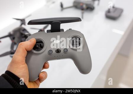 DJI Drone Remote Control in hand. Buyer chooses goods in DJI store. Stock Photo