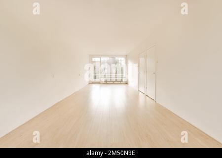 an empty room with white walls and hardwood flooring in the middle part of the room is light wood floors Stock Photo