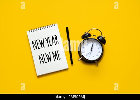 New year new me text in open notepad on yellow background. Setting goals and new years resolution. New year loading. Stock Photo