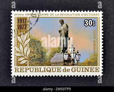 Cancelled postage stamp printed by Guinea, that shows Pushkin Monument, 60th Anniversary of the October Revolution, circa 1977. Stock Photo