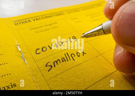 a record of vaccination against smallpox on the yellow vaccination book. Stock Photo