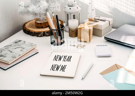 NEW YEAR NEW ME text in open notepad on table at home. Setting goals and new years resolution. New year loading. Stock Photo