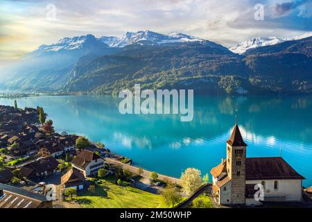 beautiful idylic nature scenery of lake Brienz with turquoise waters. Switzerland, Bern canton. Aerial view with little church in the morning light Stock Photo