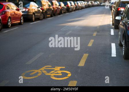 Bicycle symbol on an empty street with cars parked aside Stock Photo