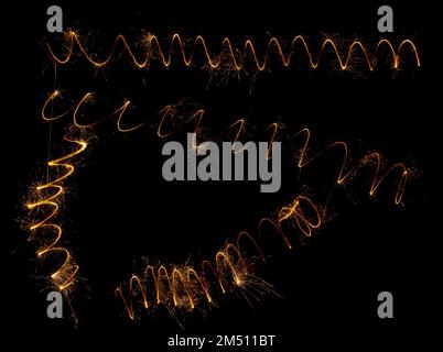 Spirals of sparklers on a black background. Stock Photo