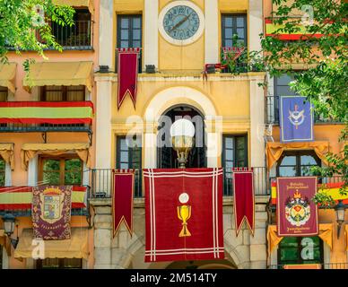Historical banners hanging from windows and balconies on buildings during Corpus Christi in Toledo, Spain Stock Photo
