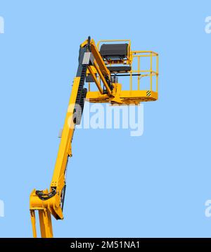 Yellow aerial work platform in front of blue sky Stock Photo