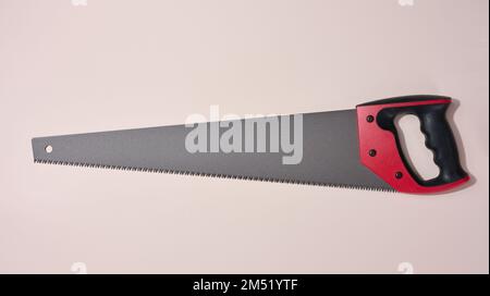 New hand saw with a rubber red handle on a white isolated background ...