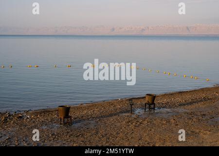 Dead Sea Beach with Buckets of Mud near Sweimeh, Jordan in the Morning Stock Photo
