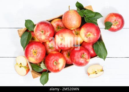 Apples apple fruits fruit from above autumn fall box with leaves wooden board Stock Photo