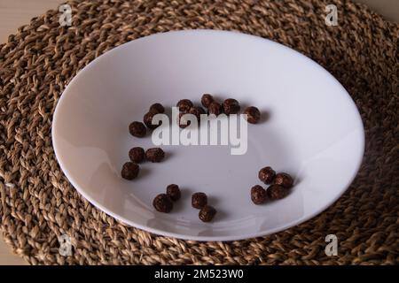 photo of several small chocolate balls on a white plate on a wicker base Stock Photo