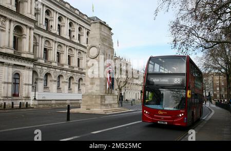 A London bus driving past the Cenotaph War Memorial, City of Westminster, London, United Kingdom, Europe Stock Photo
