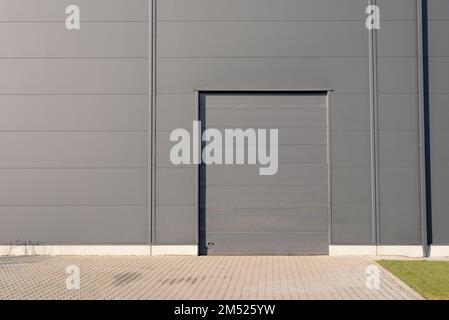 Closed grey metal door of warehouse building Stock Photo