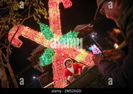 Lalitpur, Nepal. 24th Dec, 2022. People take pictures of a girl dressed as Santa Claus in front of the Christmas decorations during Christmas eve at the shopping mall in Lalitpur. Christmas Eve is the evening or entire day before Christmas Day, the festival commemorating the birth of Jesus Christ. Christmas Day is observed all-around the world. (Photo by Prabin Ranabhat/SOPA Images/Sipa USA) Credit: Sipa USA/Alamy Live News Stock Photo