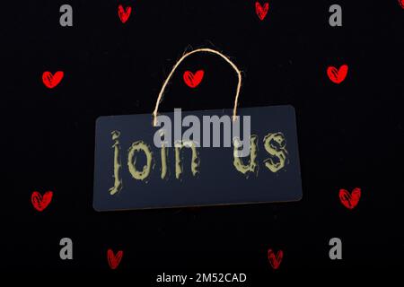 Rectangular shaped black notice board and red hearts on black background Stock Photo