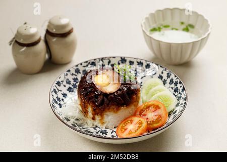 Lo Mai Gai, Steamed Glutinous Rice with Soy Sauce Chicken,  Egg, and Mushrooms. Served with Chicken Stock Soup Stock Photo