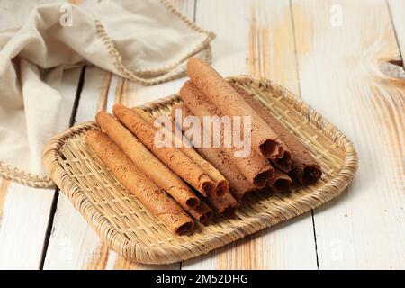 Chinese Waffle Egg Roll or Khanom Thong Muan, Thalinad Crispy Sweet Dessert. Served on Rattan Plate Stock Photo