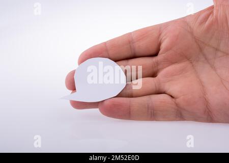 Hand holding a blank empty speech bubble made white paper Stock Photo