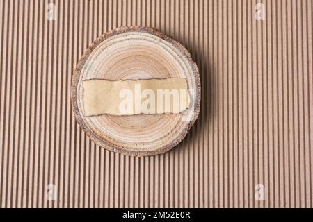 Piece of log with piece of burnt paper is on cardboard Stock Photo