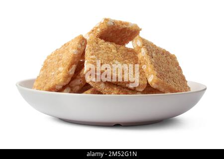coconut biscuits, textured crispy square shaped homemade cookies on a white plate isolated on white background Stock Photo