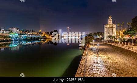 Golden tower Torre del Oro watchtower along the Guadalquivir river at night in Seville, Andalusia, Spain on 7 December 2022 Stock Photo