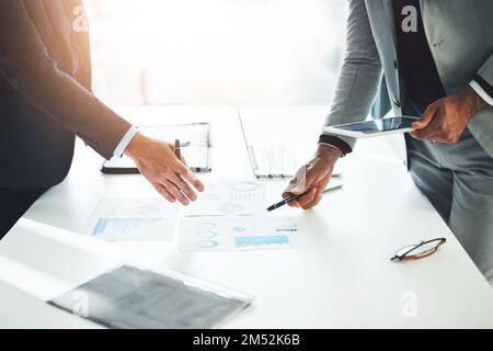 Paperwork is their speciality. two unrecognizable businessmen discussing paperwork at the table in the boardroom. Stock Photo