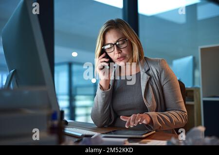 I can help you first thing in the morning. a businesswoman working late in the office. Stock Photo