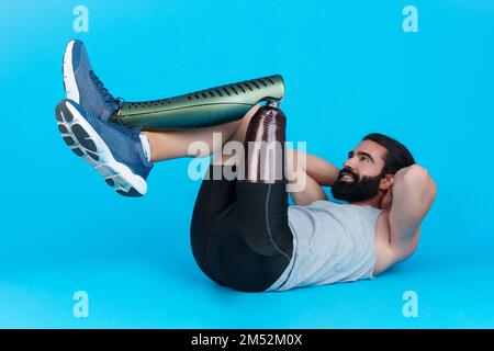 Man with a leg prosthesis doing abdominal crunches Stock Photo