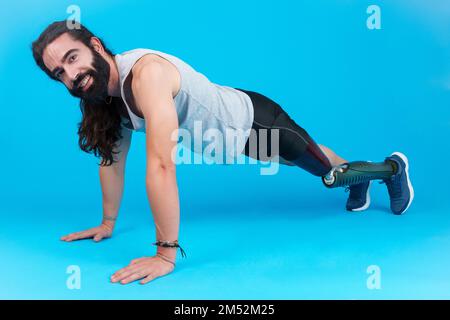 Man with a prosthetic leg doing push-ups on the floor Stock Photo