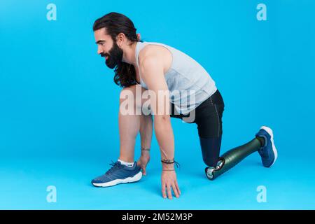 Man with amputated leg and prosthesis in sprinting position Stock Photo