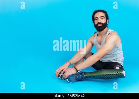 Man with a prosthetic leg sitting on the floor Stock Photo