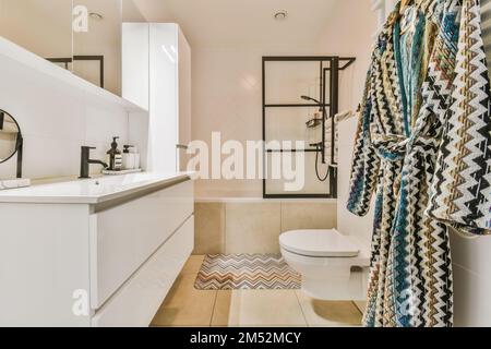 a bathroom with a toilet, shower, and bathtub in the same photo is taken from the other room Stock Photo