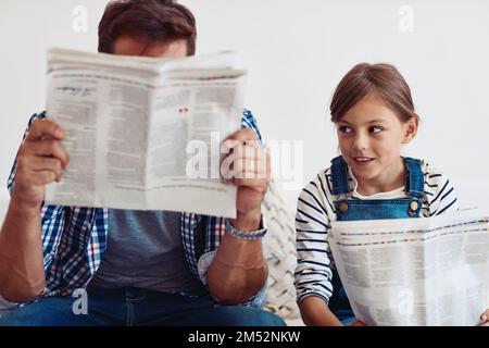 So, do you see anything interesting. an adorable little girl spending time with her father at home. Stock Photo