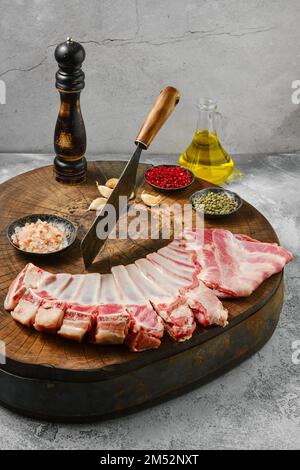 Raw lamb flap ribs with ingredients for cooking on wooden log Stock Photo