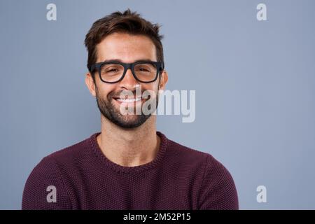 Happy with the man I am. Studio shot of a handsome and happy young man posing against a gray background. Stock Photo