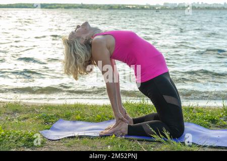 Smiling woman in camel yoga pose Stock Photo - Alamy