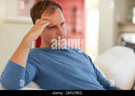 Hes got a lot on his mind. a mature man looking contemplative at home. Stock Photo