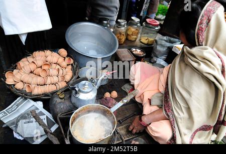 A Bengali woman preparing traditional Indian milk tea in Kolkata, India. Stock Photo