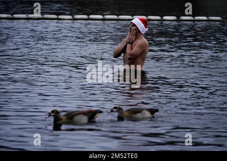 An early morning swimmer takes a dip on Christmas Day at the Serpentine, ahead of the annual Peter Pan Cup race, in central London. Picture date: Sunday December 25, 2022. Stock Photo