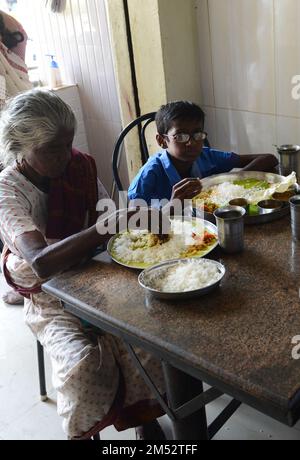 A traditional South Indian Thali meal served on a banana leaf in a restaurant in Madurai, Tamil Nadu, India. Stock Photo