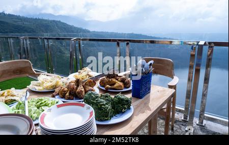 Landscape photo of food for breakfast in the morning over a beautiful lake with a mountainous background on the island of Java, Indonesia Stock Photo