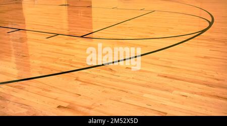 Interior of empty modern basketball indoor sport court, semigloss coating wooden floor, artificial lights reflected Stock Photo